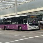 an airport shuttle bus outside a terminal