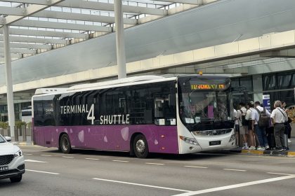 an airport shuttle bus outside a terminal