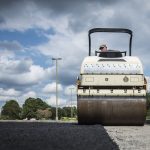 workers resurfacing a road with fresh asphalt