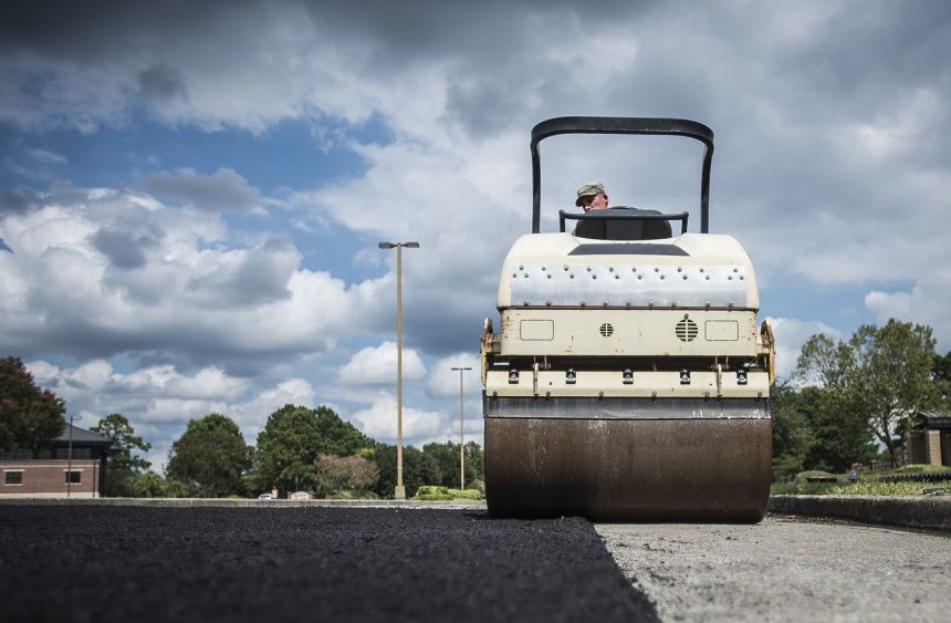 workers resurfacing a road with fresh asphalt