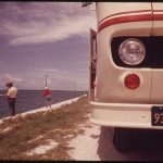 A retired couple fishing beside their travel trailer