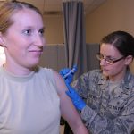Healthcare worker preparing a measles vaccine dose at a clinic